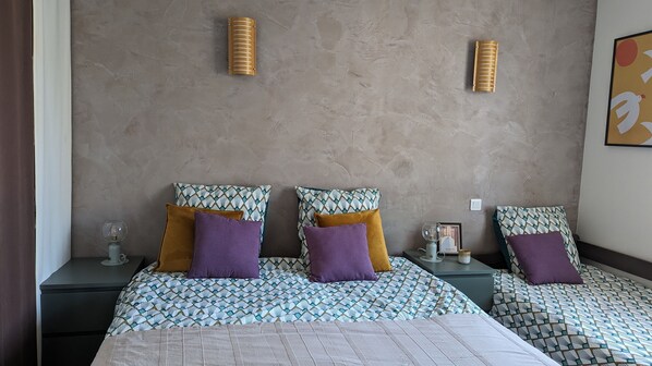 A hotel room with a large bed, two bedside tables, and a wall-mounted light fixture. - 4 bedroom villa with swimming pool, in a large lush garden, 3km from the beaches (Messanges)