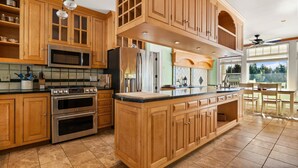 Una cocina amplia con armarios de madera, electrodomésticos de acero inoxidable y una isla grande.
