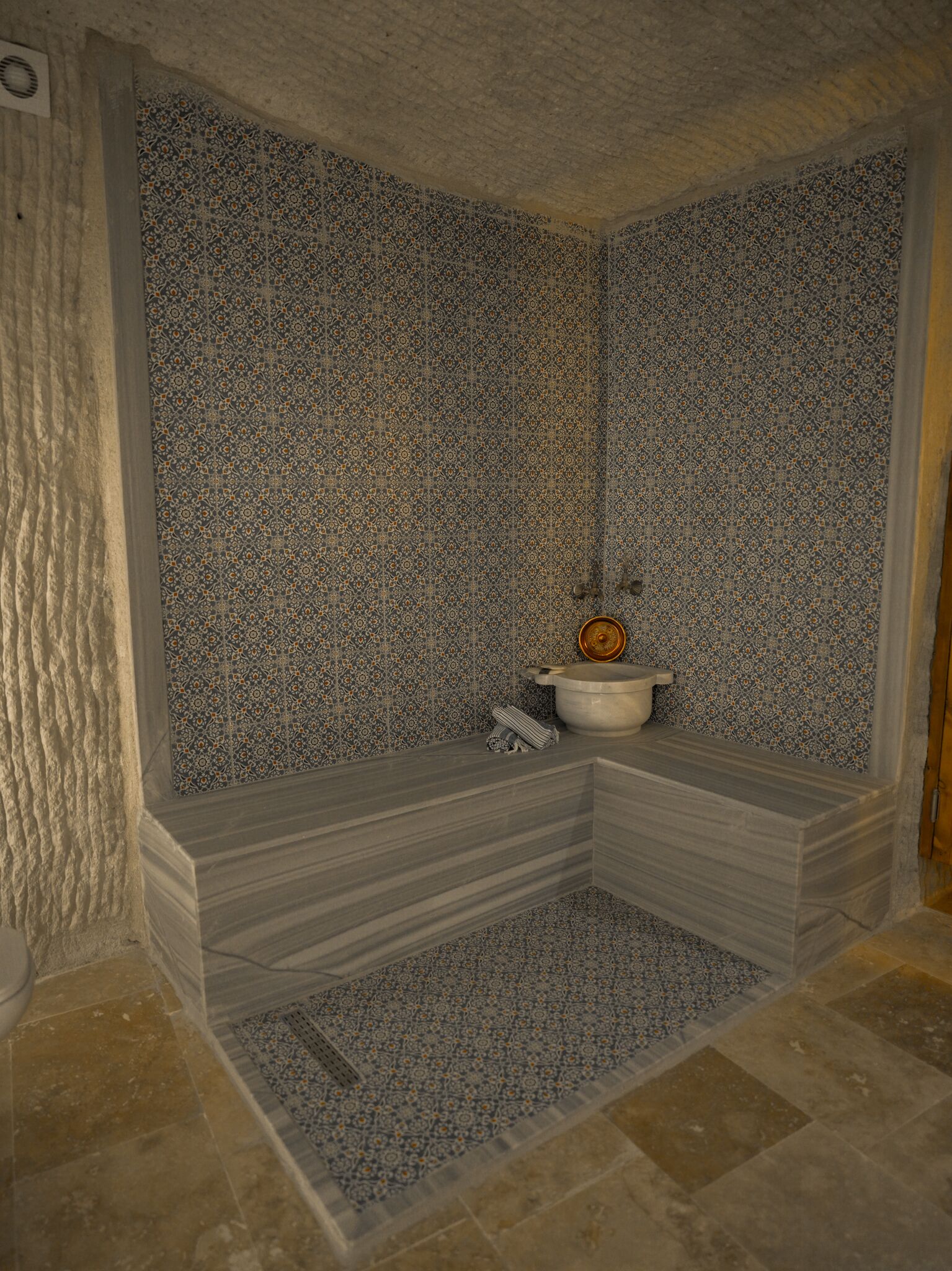 Une salle de bain avec un mur recouvert de carreaux à motifs, un lavabo et des toilettes.
