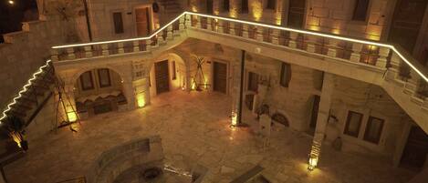 Un edificio histórico con un patio central, paredes de piedra y una escalera de caracol.