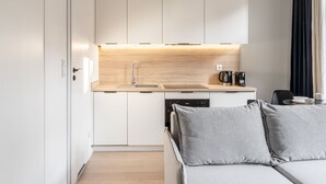 Eine moderne Küche mit weißen Schränken, einer Holz Arbeitsplatte und einem eingebauten Geschirrspüler.