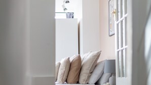A staircase leading to a room with a bed, a window with blinds, and a ceiling light fixture. - The Nine Elms Collection (London)
