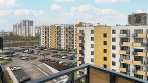 A multi-story residential building with a parking lot in front. - Stylish Apartment | Balcony (Poznan)