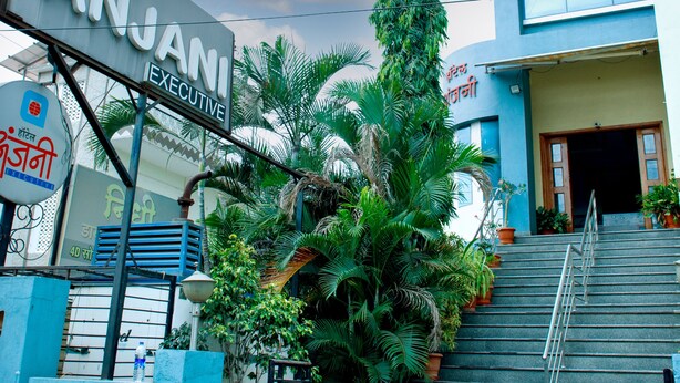 A hotel entrance with a sign reading "Hotel Anjani Executive," a staircase, and surrounding greenery. - Hotel Anjani  (Latur)