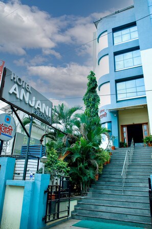 A hotel entrance with a sign reading "Hotel Anjani Executive," a staircase, and surrounding greenery. - Hotel Anjani  (Latur)