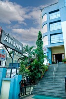 Entrada de hotel com uma placa indicando "Hotel Anjani Executive", uma escadaria e vegetação ao redor.