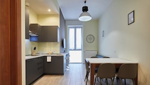 Une cuisine moderne avec un coin repas, un plancher en bois et une grande fenêtre.