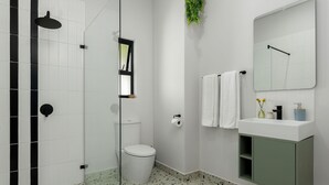 A bathroom with a shower, toilet, and sink with a mirror. - Neighbourgood First Crescent (Cape Town)