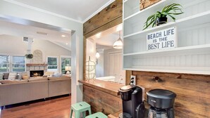 Een moderne woonkamer met een open haard, een bank en een koffiehoek.