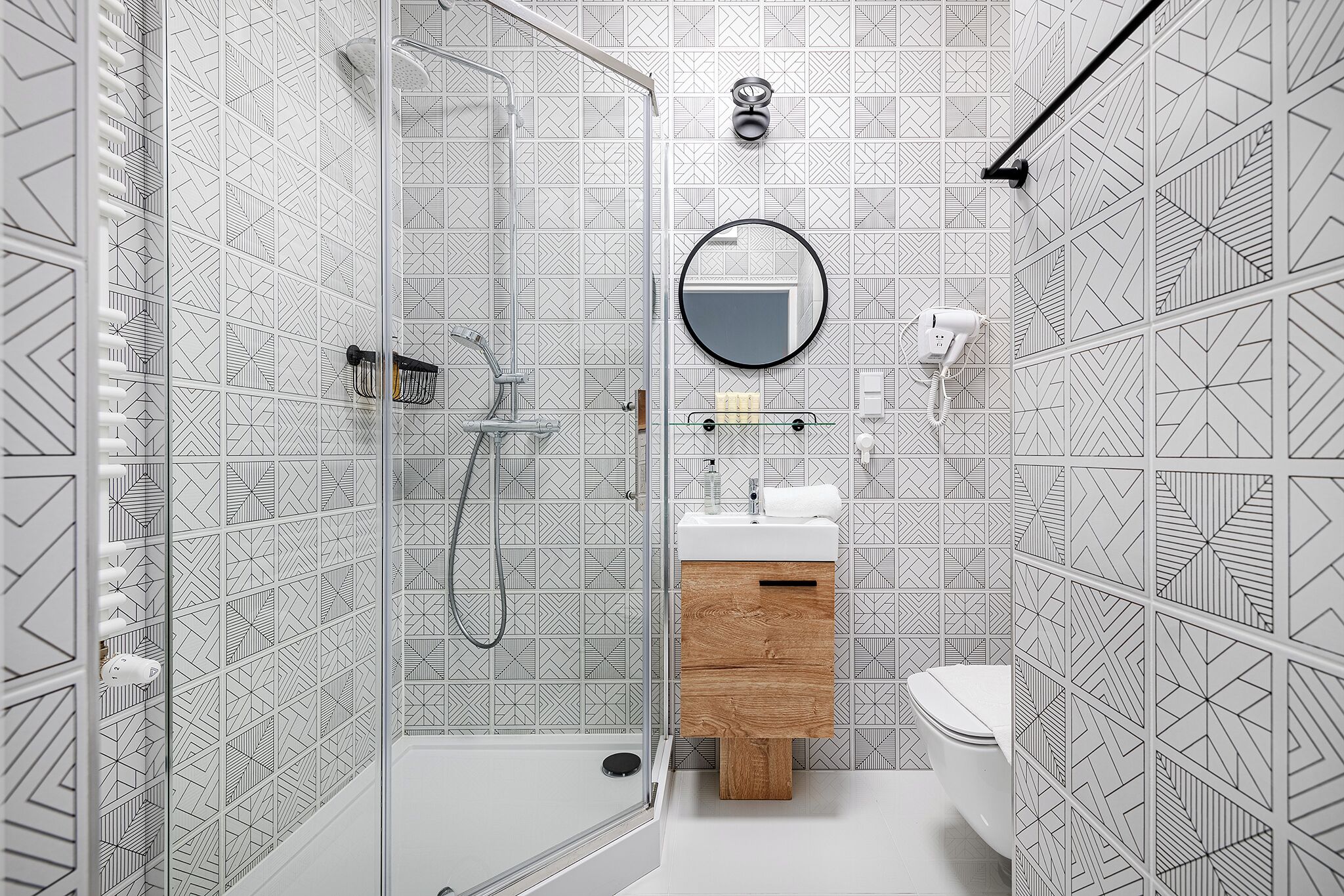 A modern bathroom with a shower, toilet, and sink.