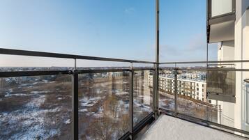 A balcony with a view of a snow-covered landscape and buildings.