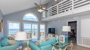 A spacious living area with a view of the ocean, a ceiling fan, and a television. - Sea Glass - Fantastic Views from this 3 BR Oceanfront Home! (Surf City)