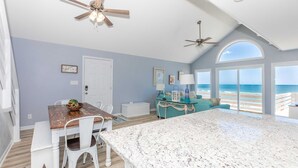 A spacious living area with a large kitchen island, a dining table, and a view of the ocean. - Sea Glass - Fantastic Views from this 3 BR Oceanfront Home! (Surf City)