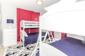 A bunk bed room with a white dresser, a lamp, and a red curtain. - Sea Glass - Fantastic Views from this 3 BR Oceanfront Home! (Surf City)