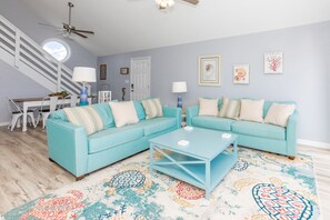 A living room with a light blue sofa set, a coffee table, and a patterned rug. - Sea Glass - Fantastic Views from this 3 BR Oceanfront Home! (Surf City)