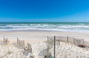 A beach with a wooden fence and beach chairs. - Beach Barn - Nice 5BR Oceanfront Home in Heart of Surf City (Surf City)