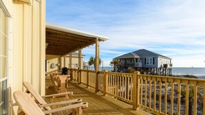 A wooden deck with benches, a covered area, and a view of the ocean. - Coconut Breeze - 105 St Dennis 4 Bedroom Home by RedAwning (Dauphin Island)