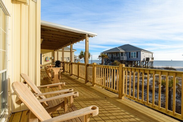 A wooden deck with benches, a covered area, and a view of the ocean. - Coconut Breeze - 105 St Dennis 4 Bedroom Home by RedAwning (Dauphin Island)