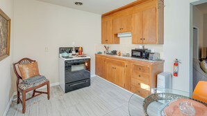 A compact kitchen with wooden cabinets, a built-in oven, and a microwave. - Downtown Oakland Studio, 6 Mi to Toll Plaza Beach! (Oakland)