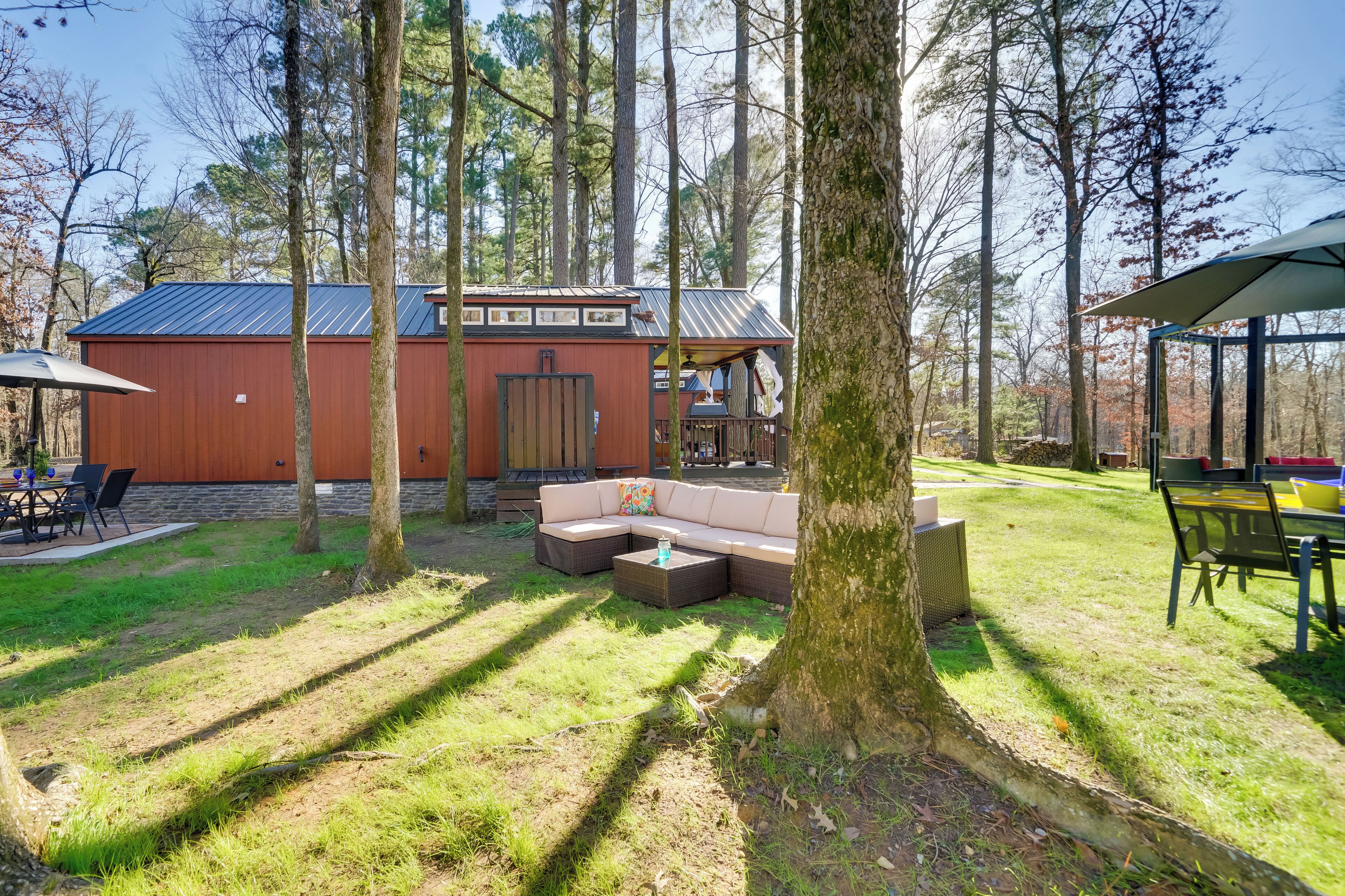 A rustic cabin with a large deck, a covered outdoor seating area, and a dining table.