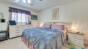 A bedroom with a bed, dresser, nightstand, lamp, and a ceiling fan. - Secluded Mancelona Home w/ Gas Grill! (Mancelona)