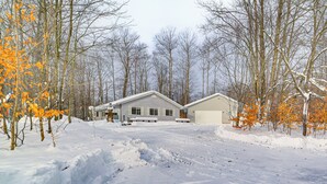 A snow-covered landscape with a house in the background. - Secluded Mancelona Home w/ Gas Grill! (Mancelona)