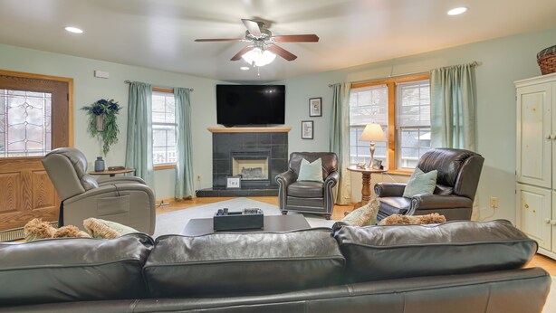 A living room with a fireplace, leather sofas, a television, and a ceiling fan. - Large Home w/ Deck & Grill ~ 9 Mi to Virginia Tech (Christiansburg)