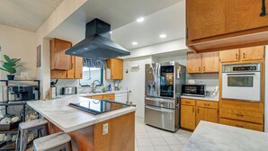 A modern kitchen with wooden cabinets, stainless steel appliances, and a marble countertop. - Family-friendly Winston Vacation Rental w/ Deck! (Winston)