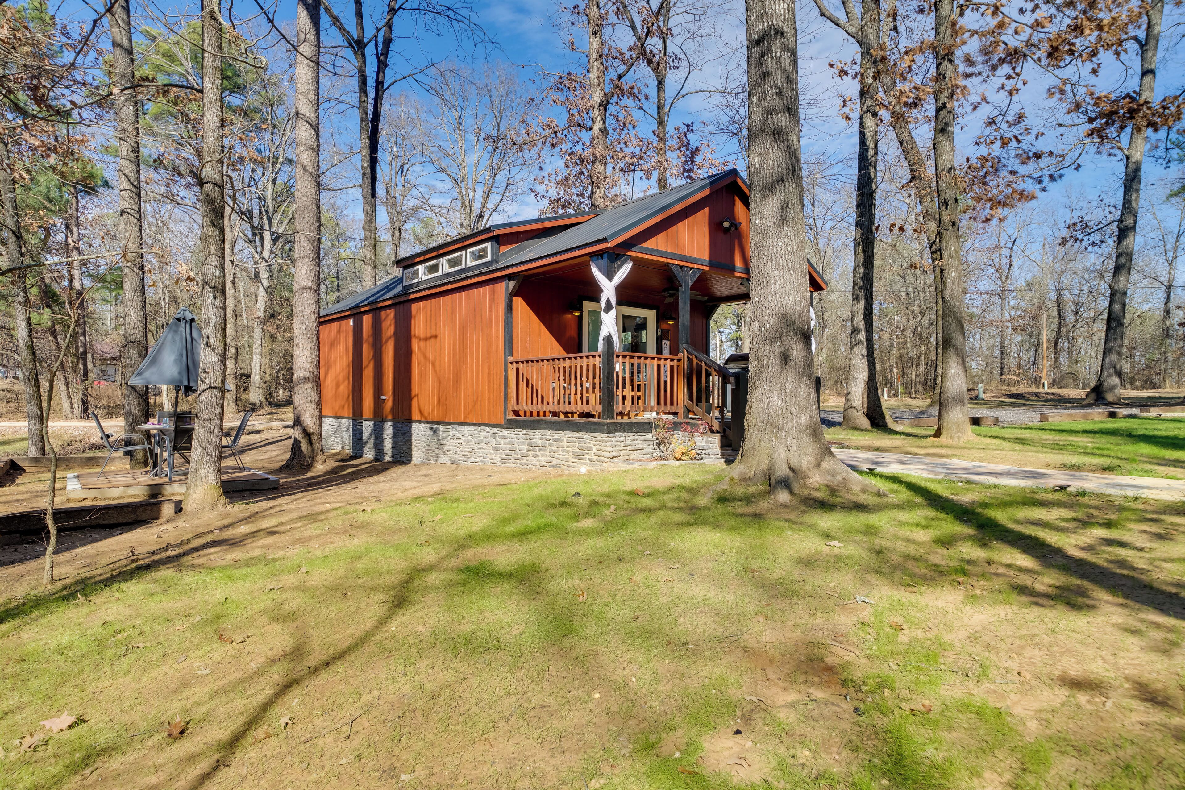 A lodge with a porch and stone foundation, surrounded by trees.