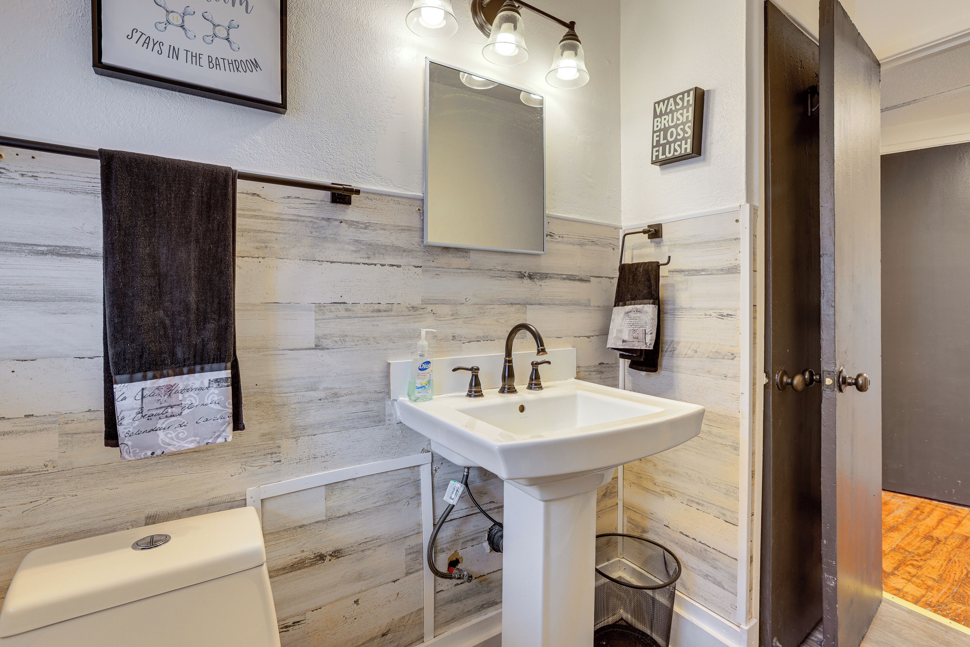 A bathroom with a white sink, a mirror, and a towel rack.