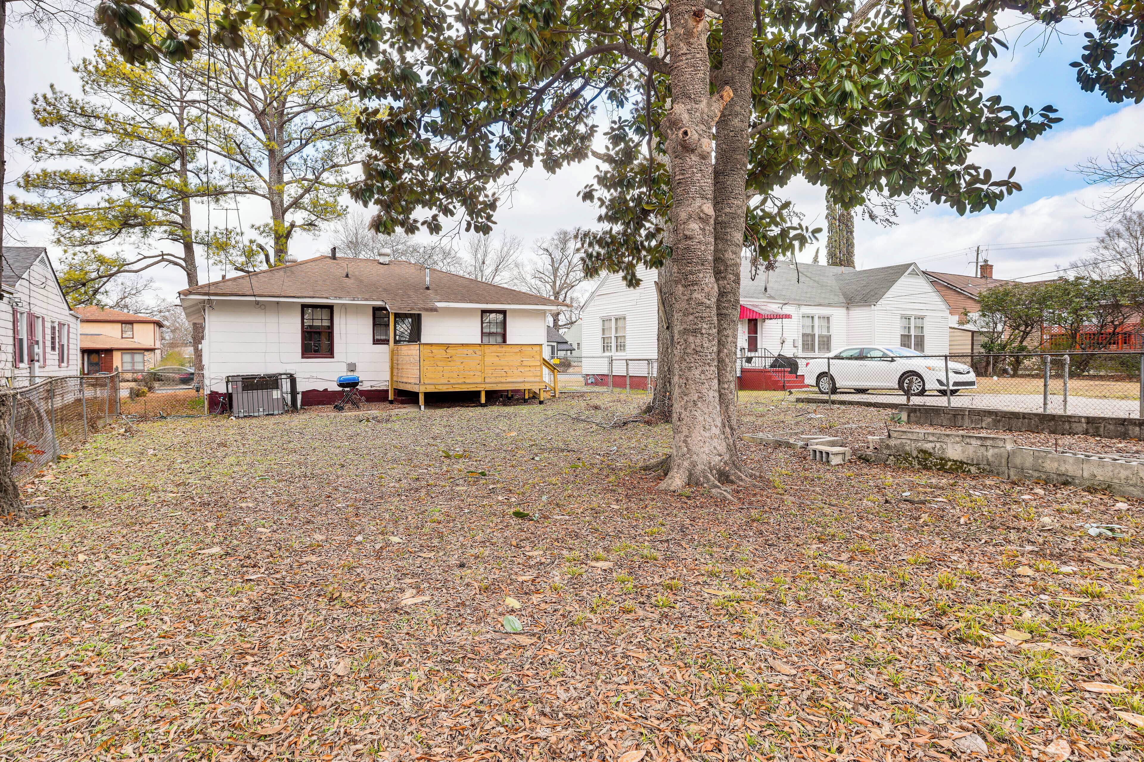 A residential area with a house under construction, a tree, and a parked car.