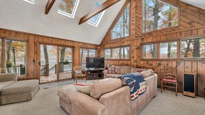 A cozy living room with a large beige sectional sofa, a television, and a fireplace.