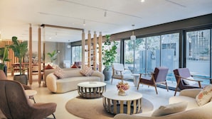 Una sala de estar moderna con un sofá, sillones, una mesa de centro y un comedor con mesa y sillas.