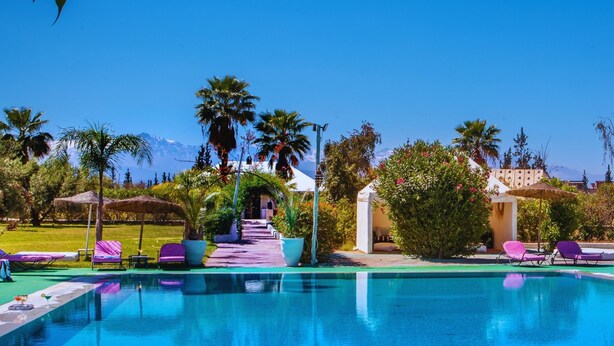 A pool area with lounge chairs, a pathway, and palm trees. - Les Jardins D'Issil Maison d'Hôtes (Sidi Abdallah Ghiat)