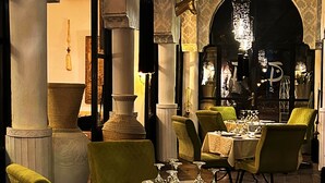 A dining area with tables set for a meal, chairs, and a chandelier. - Les Jardins D'Issil Maison d'Hôtes (Sidi Abdallah Ghiat)