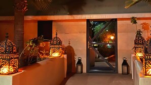 A nighttime entrance with a palm tree and decorative lanterns. - Les Jardins D'Issil Maison d'Hôtes (Sidi Abdallah Ghiat)