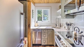 A modern kitchen with a dishwasher, stainless steel appliances, and a window providing natural light.