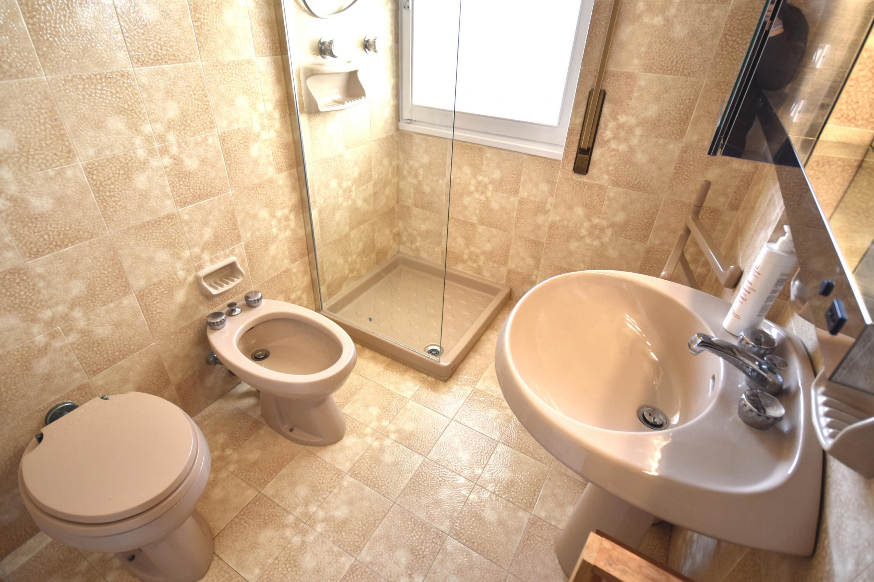 Une salle de bain équipée de toilettes, d’un bidet et d’un lavabo.
