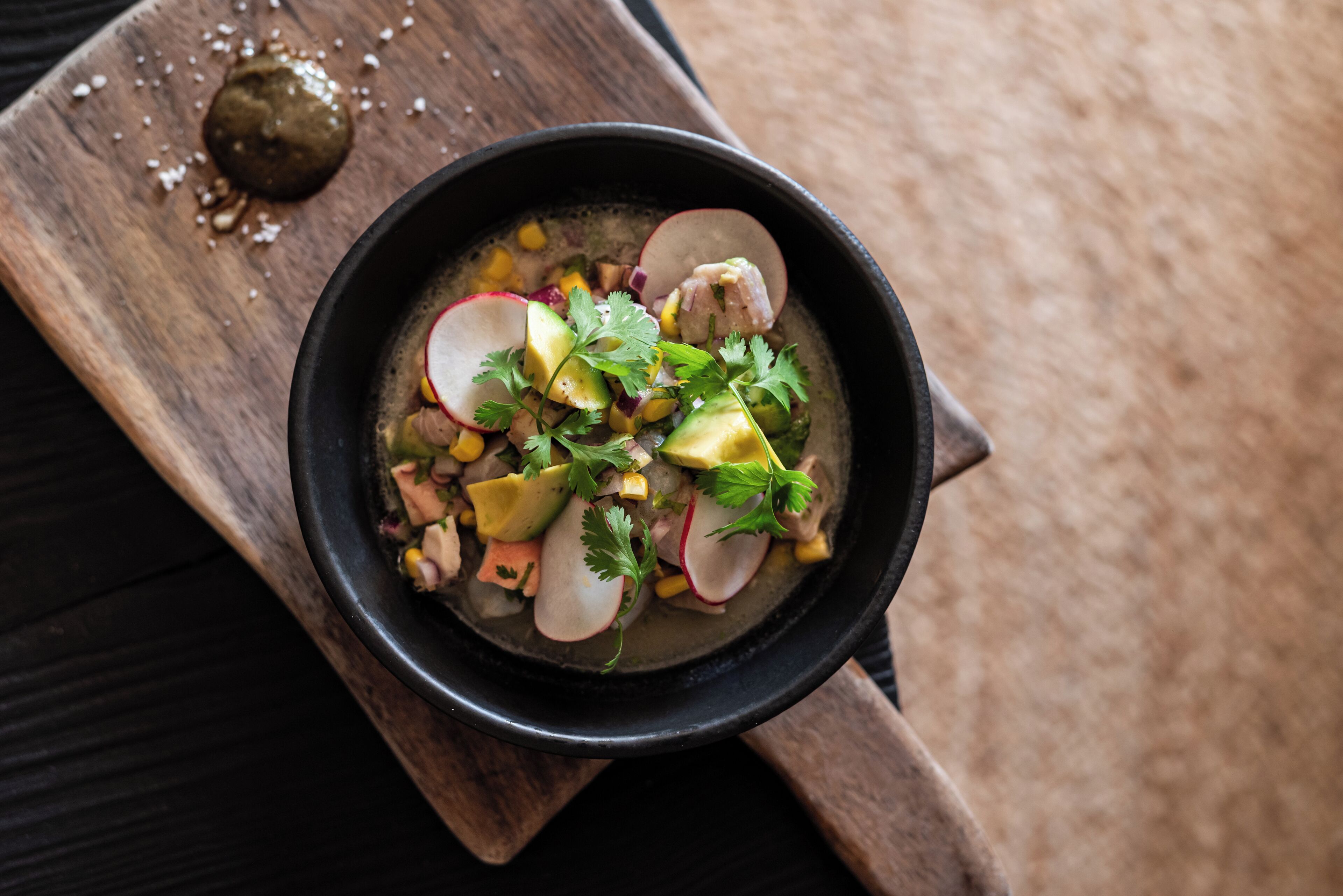 A bowl of food on a wooden board.