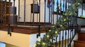 A staircase with a wrought iron railing, decorated with a garland of lights. - Bergui Guesthouse  (Guimarães)