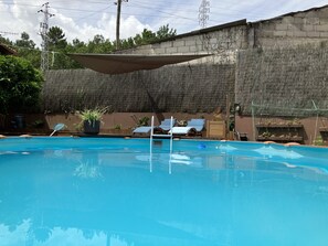 A swimming pool with lounge chairs and potted plants. - Bergui Guesthouse  (Guimarães)