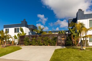 Stylish residential building with a clean design, surrounded by lush landscaping and an entrance.