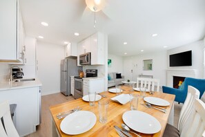 Cozy living area with a dining table for four, flat-screen TV, and fireplace.
