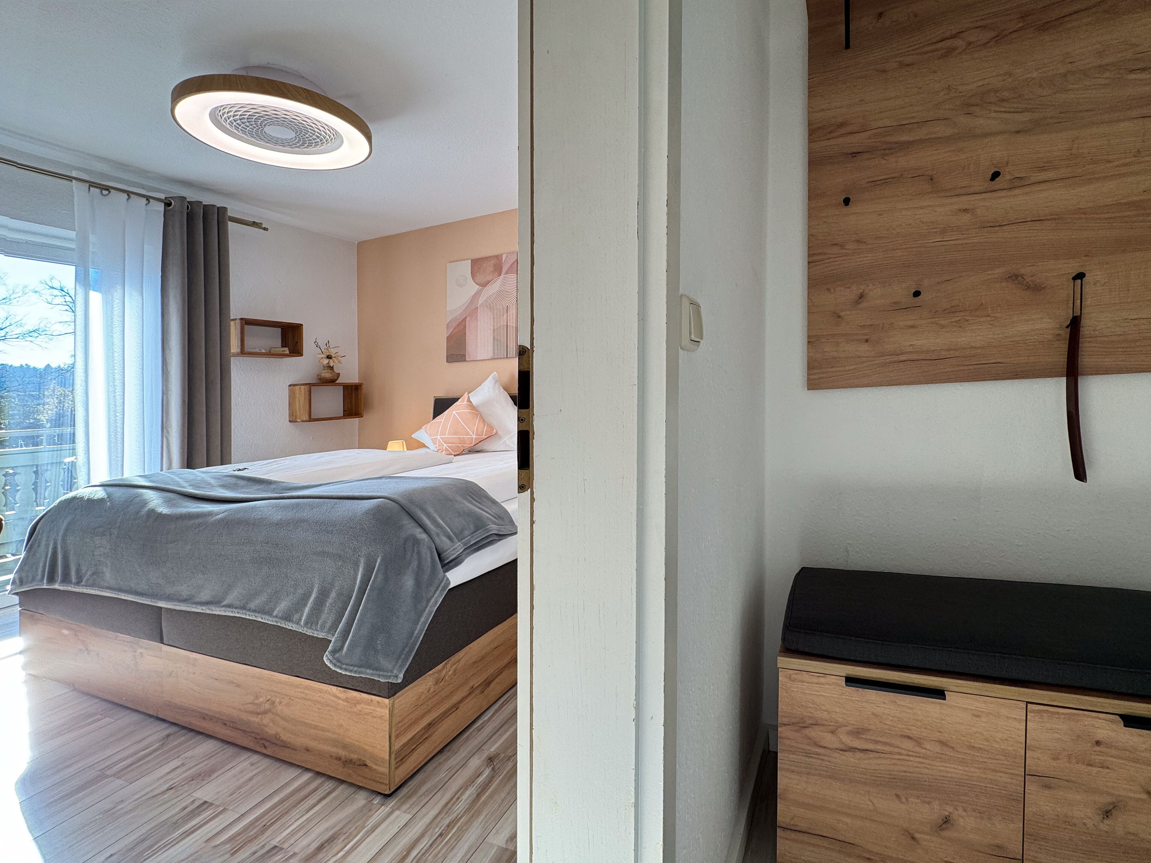 Ein modernes Schlafzimmer mit einem hölzernen Bettgestell, einem Nachttisch und einer an der Wand befestigten Holzvertäfelung.