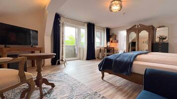 Ein Hotelzimmer mit Bett, Schreibtisch, Stuhl, Fernseher und einem großen Fenster.