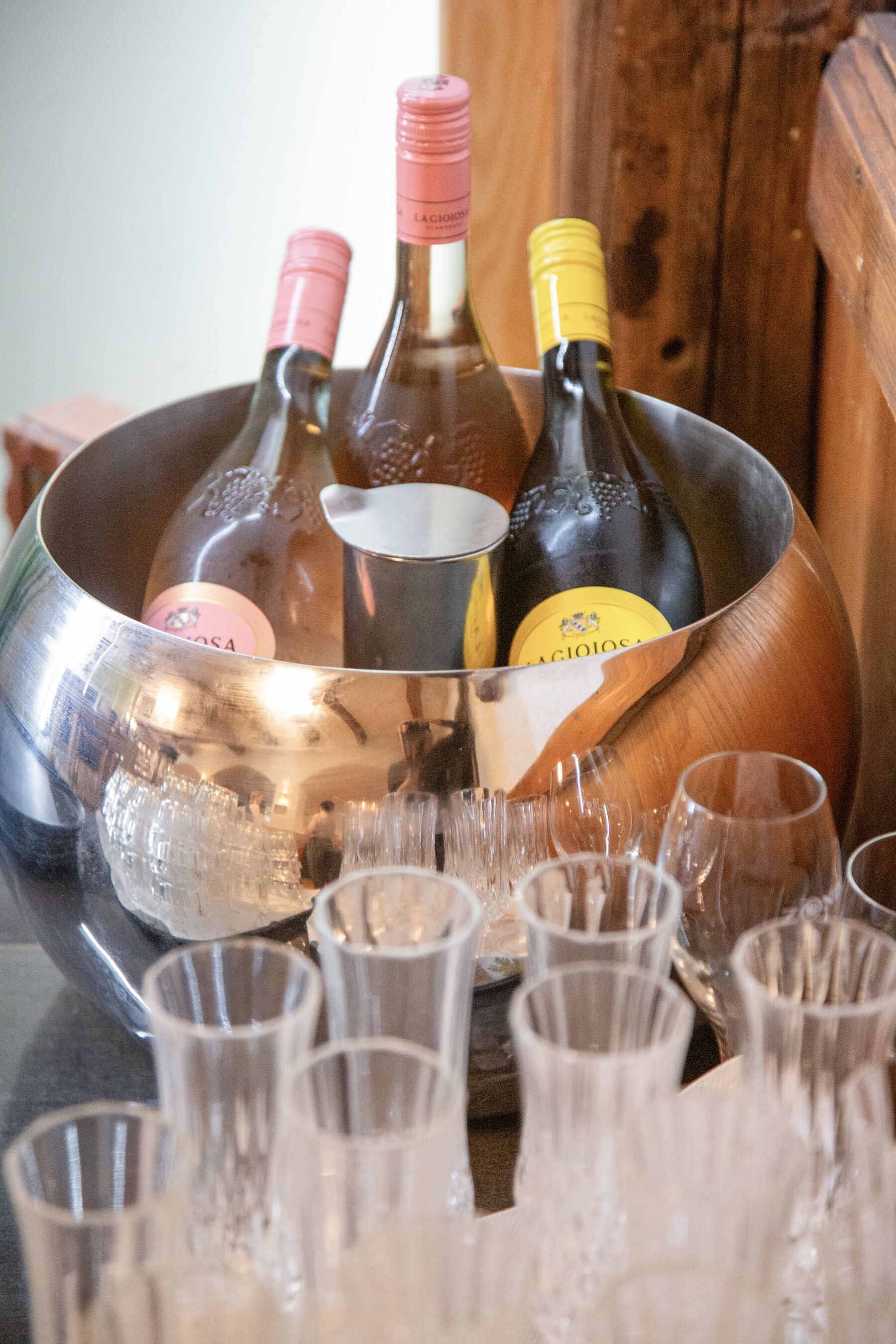 A metal container holding wine bottles and glasses.