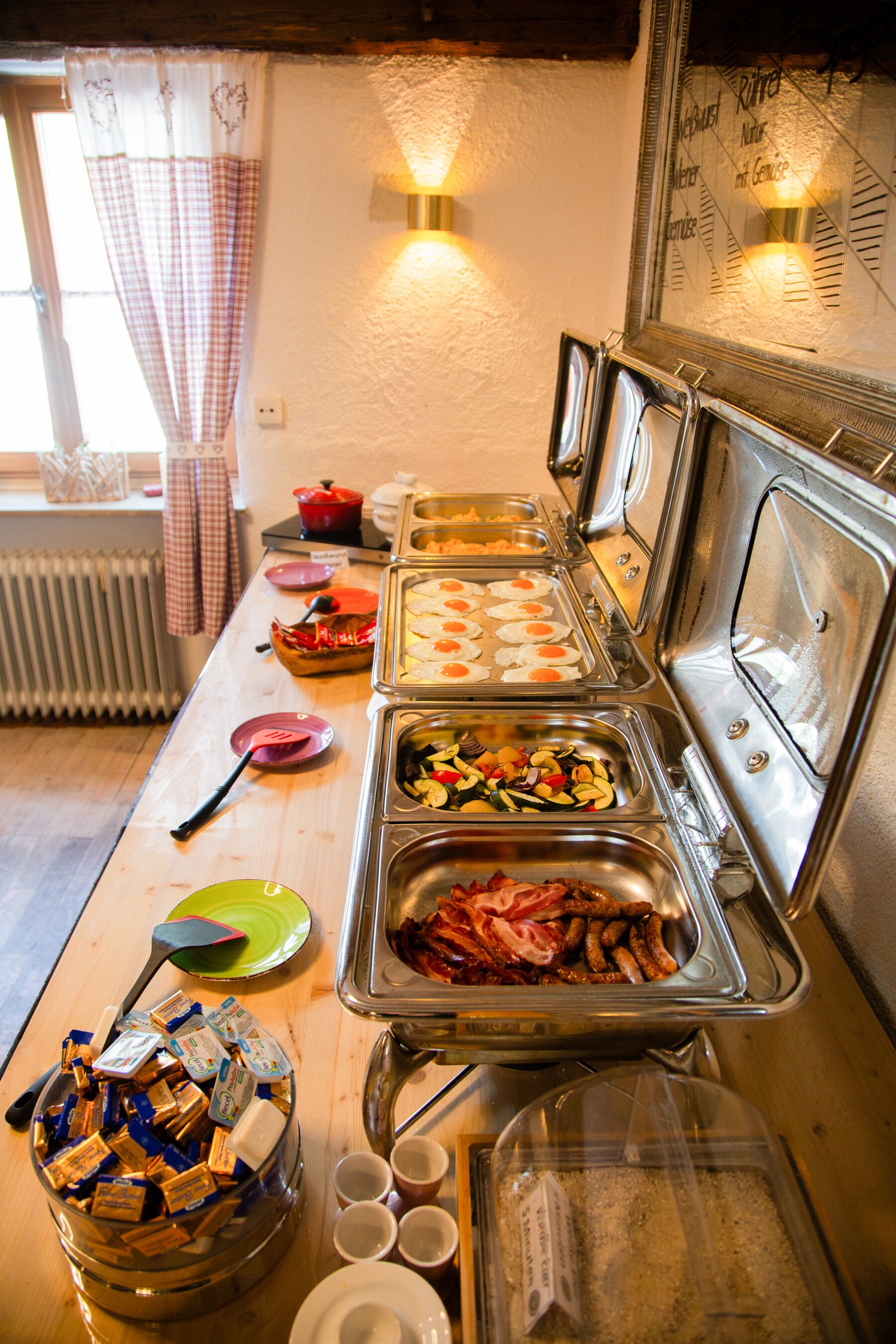 A buffet setup with various food items and utensils.