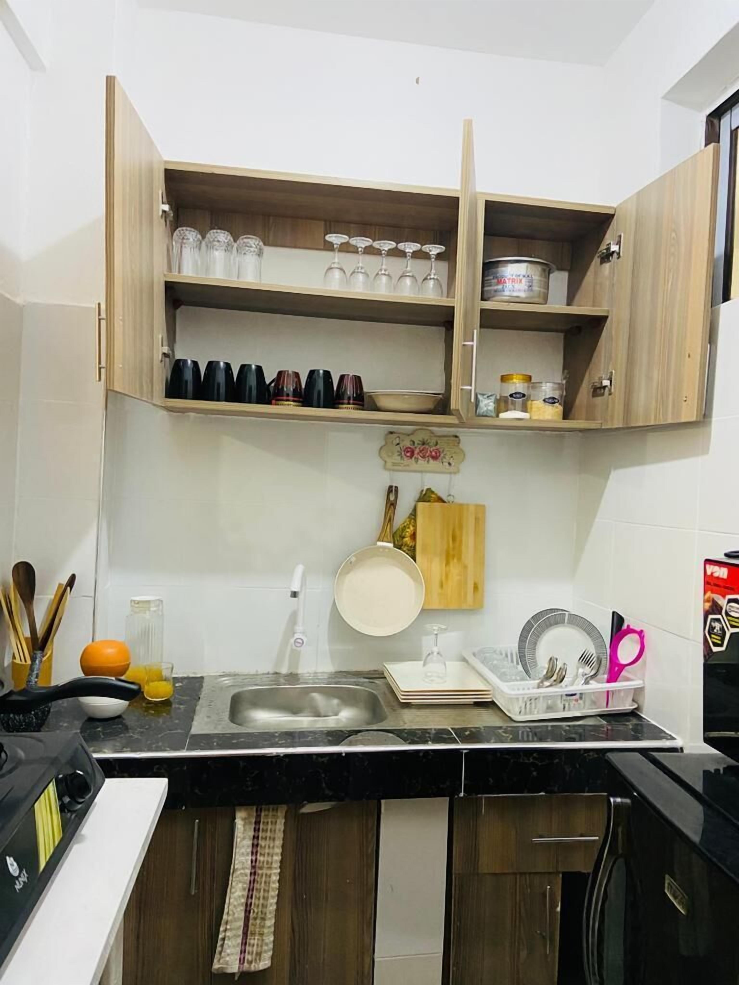 Uma cozinha com armários de madeira, uma pia e diversos utensílios.