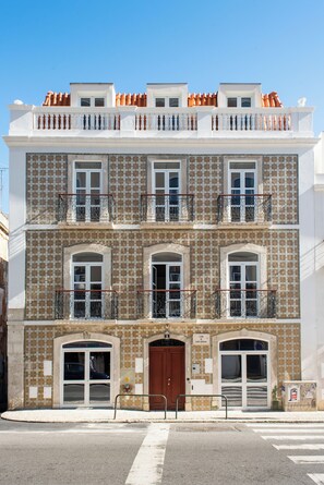 A multi-story building with a tiled facade, balconies, and a central entrance with a door. - The Haus - Santa Barbara II (Lisbon)