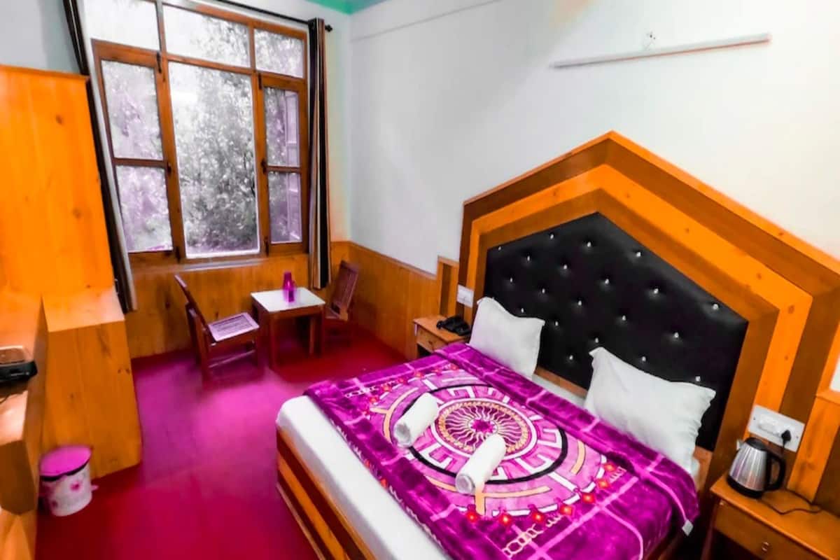 A room with a bed, a desk, a chair, and a window.